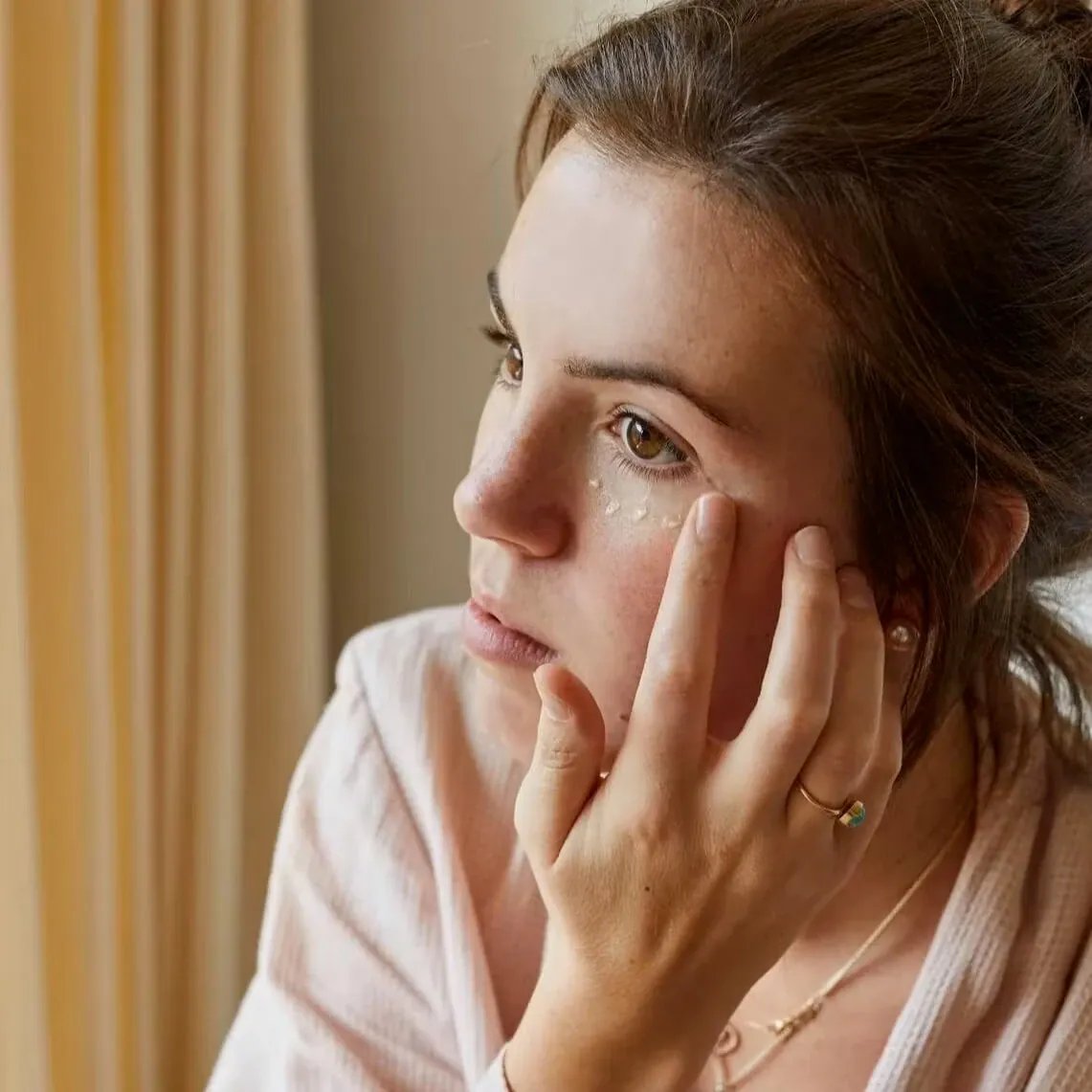 UpCircle Oogcrème met Hyaluronzuur en Koffie op gezicht met vingers
