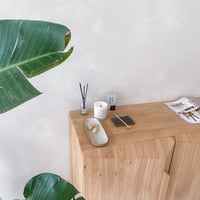 Lait de Soja Natuurlijke Geurkaars op kastje naast plant