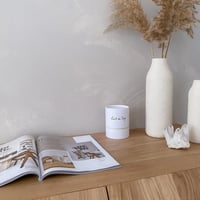 Lait de Soja Natuurlijke Geurkaars op kastje naast tijdschrift