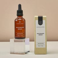 Junglück Niacinamide Serum (50 ml) flesje op sokkel naast doosje