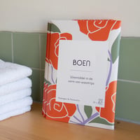 Boen Wasstrips Rozengeur & Maneschijn (32 stuks) pakjes naast handdoeken